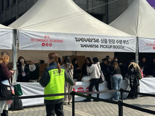 Fans collect pre-ordered BTS merchandise at the Weverse pickup booth near Gwanghwamun set up for the group’s comeback event in Seoul on March 21 2026 AJP Kim Hee-su