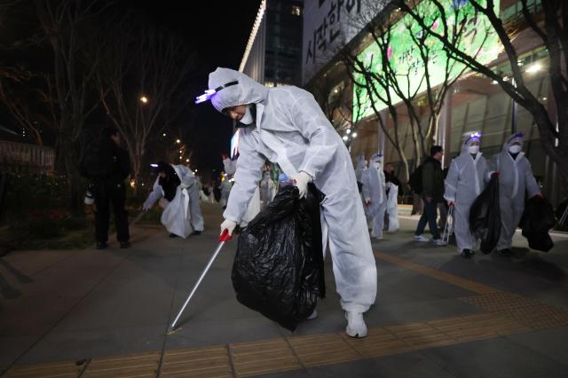 서울 종로구 광화문 광장에서 자원봉사자들이 쓰레기를 줍고 있다사진연합뉴스