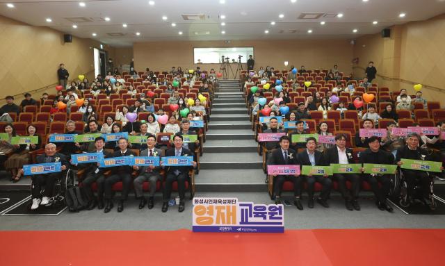 정명근 화성특례시장앞줄 왼쪽에서 다섯번째과 내빈 시민들이 21일 다원이음터 대강당에서 화성시 인재육성재단 영재교육원 개원 기념 플래카드를 들고 기념촬영을 하고 있다 사진화성시