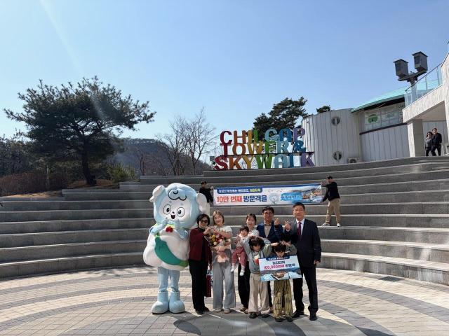 10만 방문객 돌파 기념 이벤트에서 강희선 관광진흥과장오른쪽 끝이 10만 번째 방문객 임연옥 씨왼쪽에서 다섯 번째에게 기념품을 전달한 뒤 기념 촬영을 하고 있다사진청양군