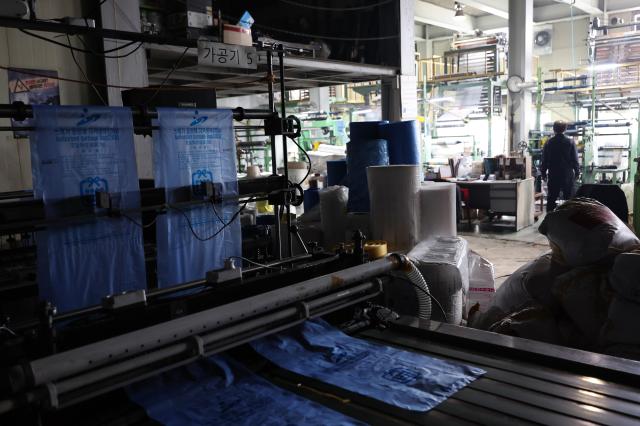 Lights are off at a production line of a plastic bag and government-designated garbage bag manufacturing plant in Ansan Gyeonggi Province on March 24 2026 where operations have been partially reduced amid unstable supply of raw materials such as polyethylene following tensions in the Middle East Yonhap 20260324