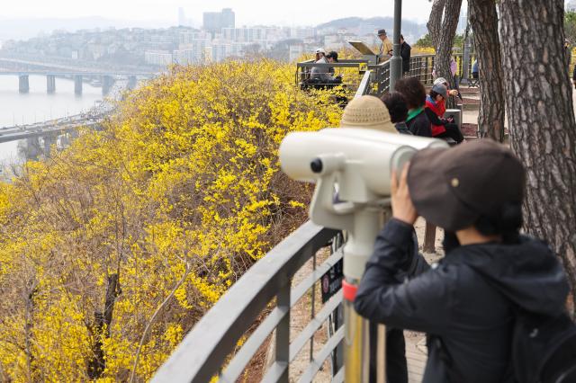 A citizen views the Seoul skyline through a telescope at Eungbongsan Mountain in Seongbuk-gu Seoul March 24 2026 AJP Han Jun-gu
