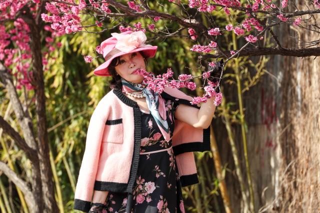A citizen poses for a photo with red plum blossoms at Hadong Plum Street in Seongbuk-gu Seoul March 23 2026 AJP Yoo Na-hyun