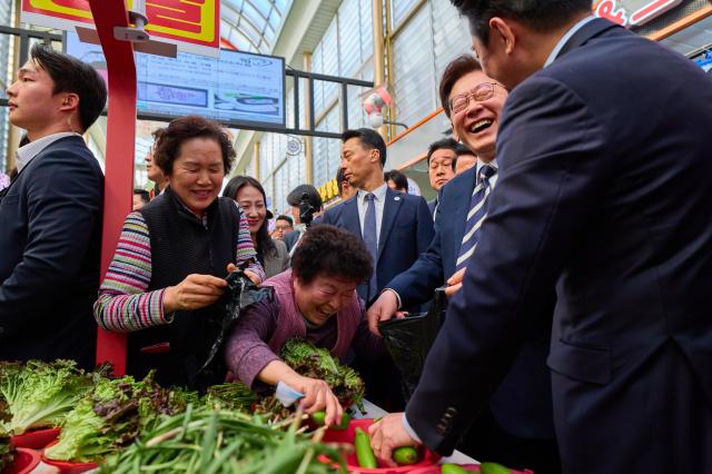 이재명 대통령이 25일 한국항공우주산업KAI에서 열린 KF-21 양산 1호기 출고식에 참석한 뒤 경남 진주시 진주중앙시장을 방문해 상인과 대화를 나누고 있다 사진연합뉴스