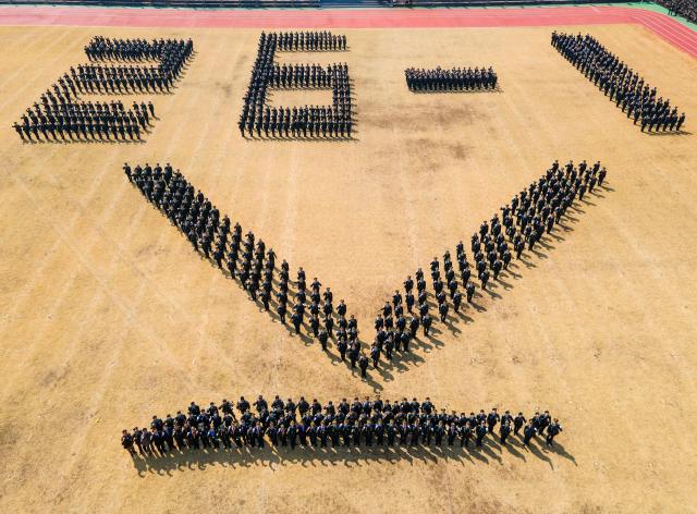 Newly commissioned non-commissioned officers NCOs pose for a commemorative photo in formation shaped like the rank insignia of “Staff Sergeant” during a commissioning ceremony for the ROK Army’s 26-1st class at the Army Non-Commissioned Officer Academy in Iksan North Jeolla Province on March 26 2026 20260326