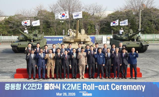 Domestic and foreign officials, partner companies and Hyundai Rotem employees pose for a photo at the ship-out ceremony for the Middle East-optimized K2 tank.
