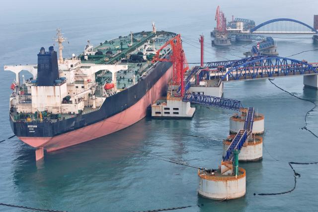 This picture taken on March 26 2026 shows an oil tanker unloading crude oil at a port in Yantai in Chinas eastern Shandong province AFP-Yonhap