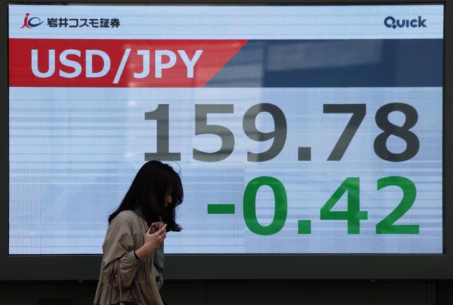 한 여성이 30일 일본 도쿄의 한 증권사 외부에 설치된 엔화와 미국 달러 환율 표시 화면 앞을 지나가고 있다 사진로이터연합뉴스