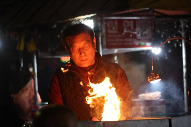 A vendor prepares food at a pojangmacha in Yeongdo-gu Busan March 28 2026 AJP Han Jun-gu