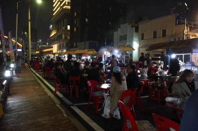 Visitors enjoy food and drinks at pojangmacha on the street food stall street in Yeongdo-gu Busan March 28 2026 AJP Han Jun-gu
