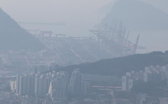 Hazy conditions obscure the view of the city and the Sinseondae container terminal from Hwangnyeongsan Mountain in Nam-gu Busan on March 10 2026 Yonhap