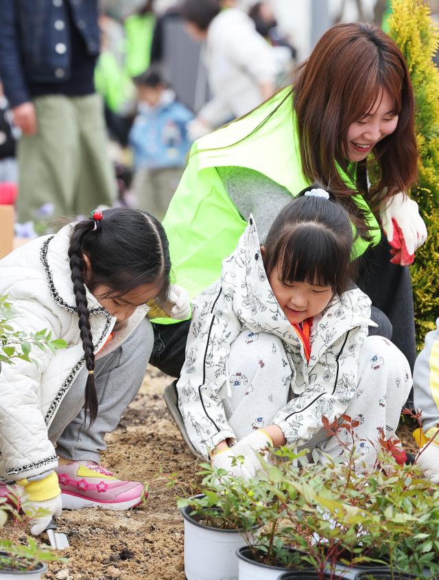 Children plant trees during a tree-planting event marking the 81st Arbor Day at Daeyupyeong Park in Jangan-gu Suwon Gyeonggi Province on March 31 2026 Yonhap
