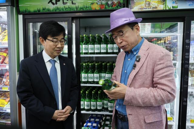 소상공인시장진흥공단이 1일 대전 신도꼼지락시장에서 선양소주·한국수퍼체인유통사업협동조합과 골목상권 활성화를 위한 동네슈퍼 한정 착한소주 공급 업무협약을 체결했다 사진은 유통 현황을 점검 중인 인태연 소진공 이사장왼쪽과 조웅래 선양 회장