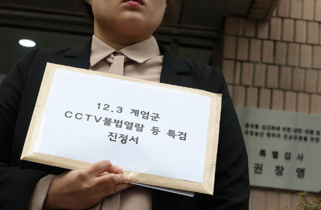 민변 등 시민사회단체 회원이 1일 경기도 과천 2차종합특검 사무실 앞에서 열린 123계엄군 CCTV 불법열람 등 특검 진정 기자회견에서 철저한 수사를 촉구하며 진정서를 들고 있다 사진연합뉴스