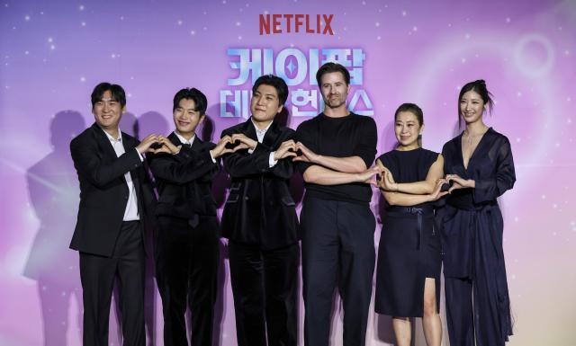 Attendees pose for a photo during a press conference celebrating the Academy Award win of the Netflix film K-Pop Demon Hunters at CGV Yongsan I’Park Mall in Seoul on April 1 2026 From left composers Nam Hee-dong Lee Yoo-han Kwak Joong-kyu Chris Appelhans director Maggie Kang and singer-songwriter Lee Jae 20260401