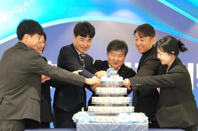 HK inno.N CEO Kwak Dal-won, fourth from right, and long-serving employees cut a cake to mark the company’s 42nd anniversary. [Photo=HK inno.N]