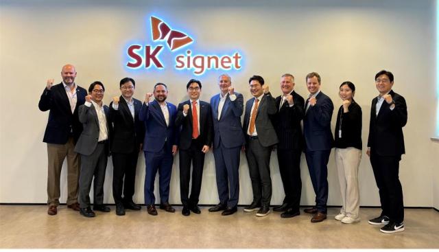 이미지1 SK시그넷 조형기 대표이사가 존 먼스 미국 플라노 시장 및 관계자들과 기념촬영을 하고 있다사진SK시그넷