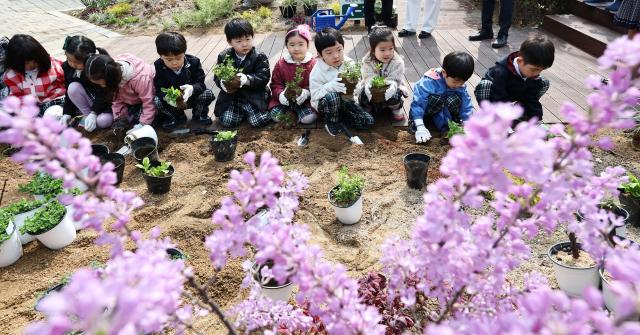 Children plant trees and flowers at the Garden Forest of Participation event held at Yangjaecheon Gaepo-dong Neighborhood Park in Gangnam-gu Seoul to mark Arbor Day April 3 2026 Yonhap