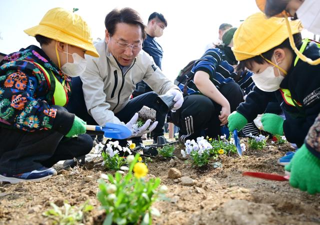유정복 인천광역시장이 3일 미추홀구 문학공원에서 열린 제81회 식목일 나무심기 행사에서 어린이들과 꽃을 심고 있다 사진인천시