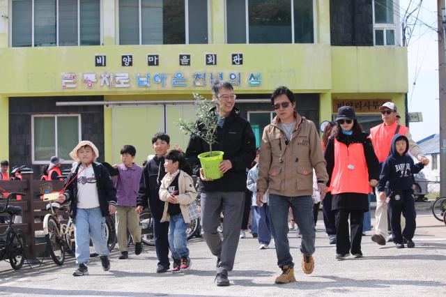 드론배송된 올리브묘목을 농장으로 운반하는 한국관광공사 제주지사장왼쪽과 비양리장 사진한국관광공사