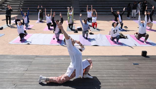 A yoga teacher of Viveka Yoga leads participants during an outdoor yoga session at Namsangol Hanok Village in Seoul on April 7 2026 ahead of the International Day of Yoga AJP Han Jun-gu