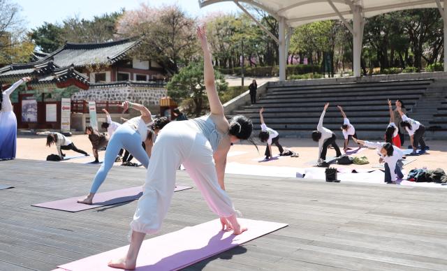 Yoga teachers from the Korea Yoga Association lead participants during an outdoor yoga session at Namsangol Hanok Village in Seoul on April 7 2026 ahead of the International Day of Yoga AJP Han Jun-gu