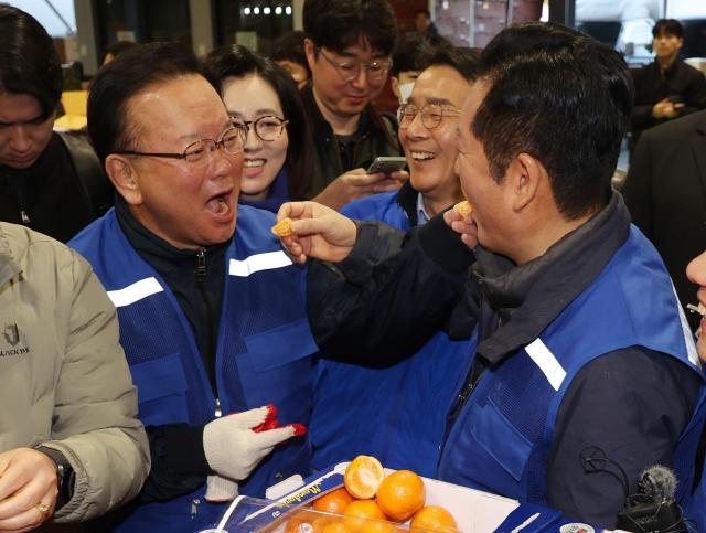 정청래 더불어민주당 대표와 민주당의 대구시장 후보로 확정된 김부겸 전 총리가 8일 오전 대구 북구 매천동 농수산물도매시장을 찾아 민생현장을 살피며 귤을 맛보고 있다 사진연합뉴스