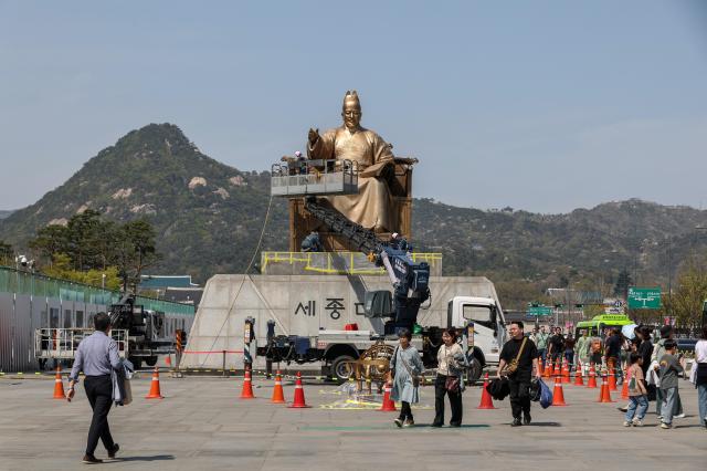 Citizens pass by as cleaning work is underway on the statue of King Sejong at Gwanghwamun Square in central Seoul on April 132026 AJP Yoo Na-hyun 20260413