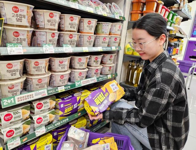 모델이 CU 매장에서 즉석밥 상품을 보고 있다 사진CU