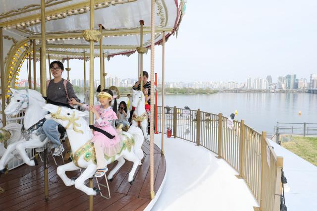 Citizens ride a carousel at Mulbit Square in Yeouido Hangang Park Yeongdeungpo-gu Seoul April 14 2026 AJP Han Jun-gu