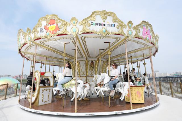 Visitors ride a carousel at Mulbit Square in Yeouido Hangang Park Yeongdeungpo-gu Seoul April 14 2026 AJP Han Jun-gu
