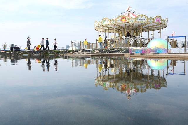 Citizens board a carousel at Mulbit Square in Yeouido Hangang Park Yeongdeungpo-gu Seoul April 14 2026 AJP Han Jun-gu
