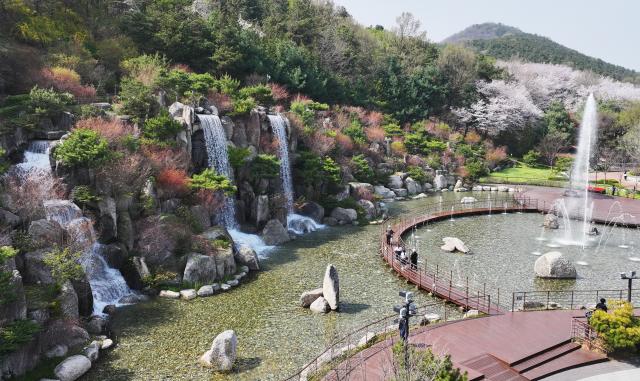 때 이른 초여름 날씨를 보인 13일 경기도 안산시 노적봉 폭포공원을 찾은 시민들이 시원하게 쏟아지는 폭포수를 바라보고 있다.[사진=연합뉴스]