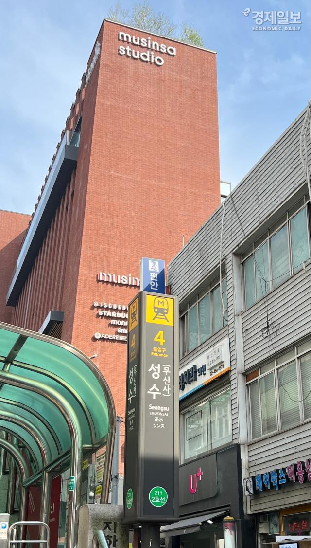 붉은색 벽돌로 지어진 무신사 스튜디오musinsa studio 건물 앞 지하철 2호선 성수역 4번 출구 폴사인에 역명 병기 사업으로 추가된 무신사라는 글자가 표기되어 있다 사진전지수 기자