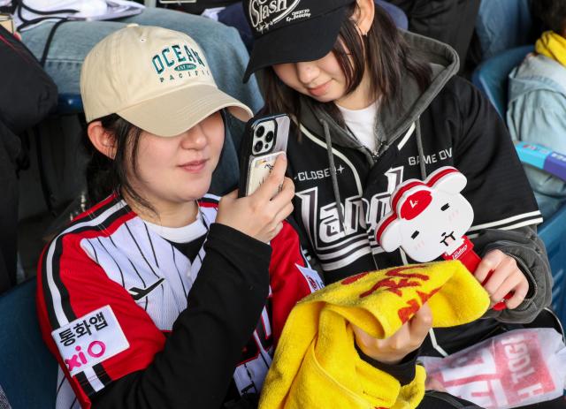 11일 서울 잠실야구장에서 열린 2026 프로야구 LG 트윈스와 SSG 랜더스 경기에서 팬들이 굿즈를 들고 인증 사진을 찍고 있다. AJP 유나현