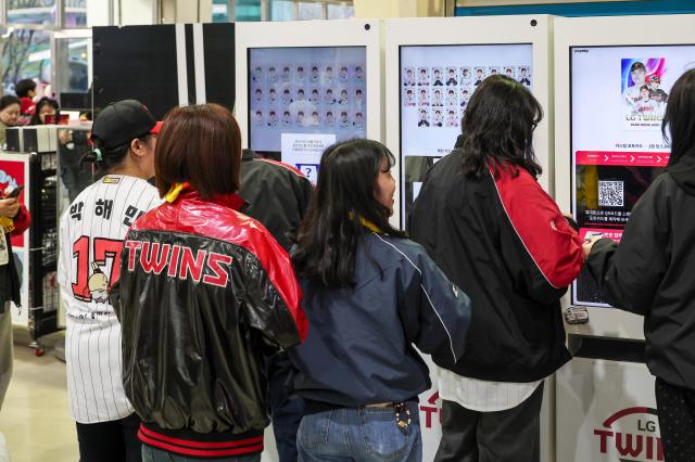11일 서울 잠실야구장 내 LG 트윈스 굿즈샵에서 팬들이 커스텀 포토카드를 뽑기 위해 키오스크 앞에 줄을 서고 있다.