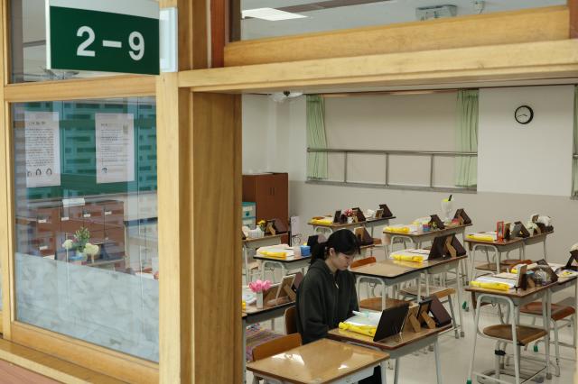 A citizen sits at a students desk and looks at a photo of the victim at the Memorial Classroom of the 416 Life and Safety Education Center in Ansan Gyeonggi Province April 15 AJP Han Jun-gu