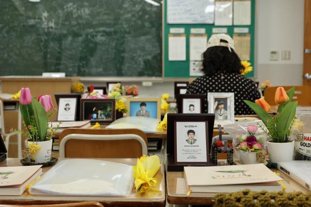 A citizen sits at a students desk and looks at a photo of the victim at the Memorial Classroom of the 416 Life and Safety Education Center in Ansan Gyeonggi Province April 15 AJP Han Jun-gu
