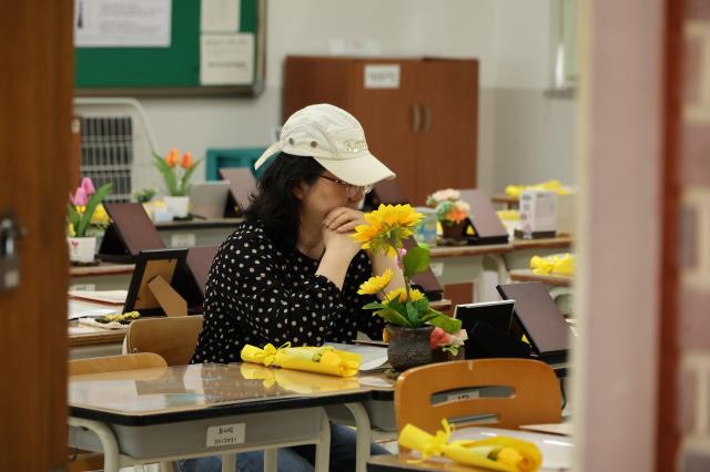 A citizen sits at a students desk and looks at a photo of the victim at the Memorial Classroom of the 416 Life and Safety Education Center in Ansan Gyeonggi Province April 15 AJP Han Jun-gu