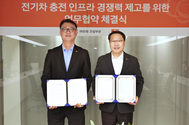 ㈜한화 건설부문 김민석 건축사업본부장왼쪽과 E1 김수근 영업본부장오른쪽이 전기차 충전기 공급 및 운영을 위한 전략적 파트너십 체결하고 기념촬영을 하고 있다 사진한화  건설부문