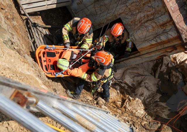 Firefighters take part in a rescue drill simulating a sinkhole that buried vehicles during a joint disaster response exercise at a construction site in the Gyosan public housing district in Cheonhyeon-dong Hanam Gyeonggi Province on April 15 2026 AJP Yoo Na-hyun
