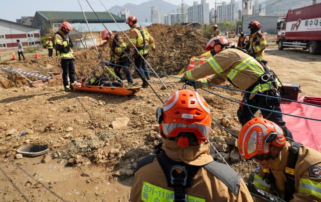Firefighters take part in a rescue drill simulating a sinkhole that buried vehicles during a joint disaster response exercise at a construction site in the Gyosan public housing district in Cheonhyeon-dong Hanam Gyeonggi Province on April 15 2026 AJP Yoo Na-hyun
