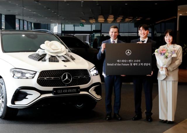  왼쪽부터 마티아스 바이틀 메르세데스-벤츠 코리아 대표이사와 RoF 1호 차량을 인도받은 안욱주 고객과 조영옥 고객이 메르세데스-벤츠 구리 전시장HS효성더클래스에서 기념촬영을 하고 있다