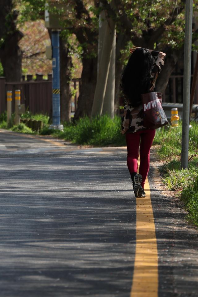 A citizen shields their face from the sun with their hand while walking near Anyangcheon Stream in Anyang Gyeonggi Province April 16 2026 AJP Han Jun-gu