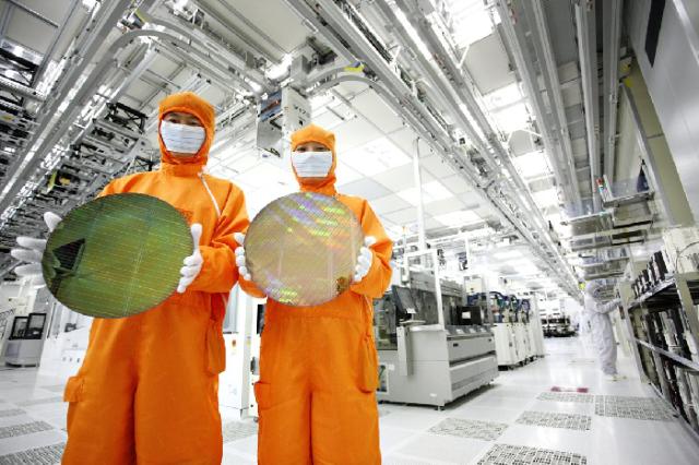 SK하이닉스 반도체 생산라인 클린룸에서 직원들이 웨이퍼를 들어보이고 있다 사진SK하이닉스
