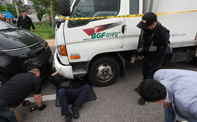 경찰이 20일 경남 진주시 정촌면 BGF로지스 진주센터에서 화물연대 관계자 1명이 숨지고 2명이 다친 사고와 관련해 현장에서 사고 차를 조사하고 있다 사진연합뉴스