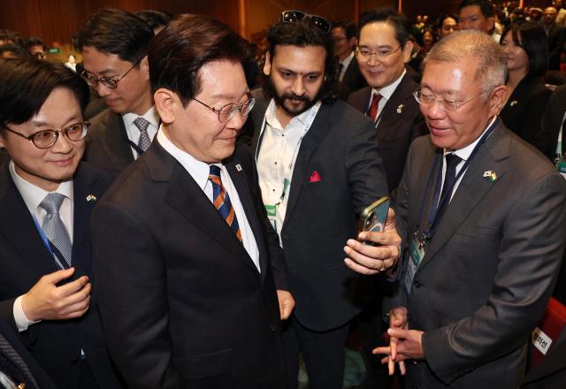 South Korean President Lee Jae Myung takes a selfie with Indian business leaders after attending the Korea-India Business Forum at Bharat Mandapam Convention Center in New Delhi on April 20 2026 To his right is Hyundai Motor chair Euisun Chung and Samsung Group chair Lee Jae-yong in the back Yonhap
