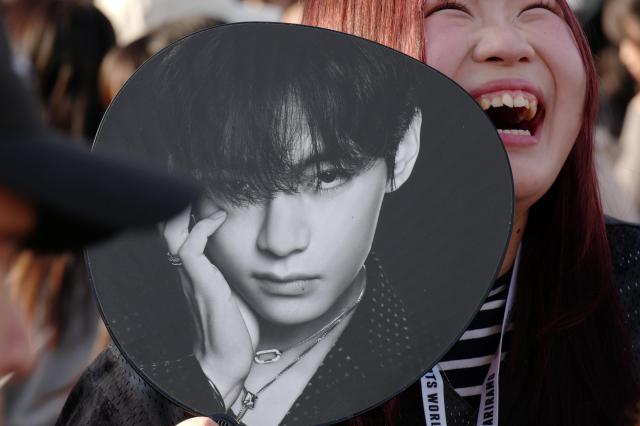 A K-pop fan smiles prior to the BTS World Tour concert outside Tokyo Dome Friday April 17 2026 in Tokyo AP-Yonhap 