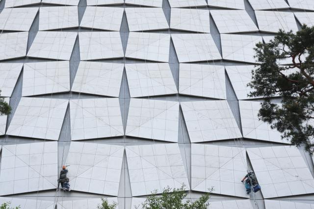 Rope access workers wash the exterior wall of a building near Jamsil Seoul as fine dust levels reach unhealthy levels April 21 2026 AJP Han Jun-gu