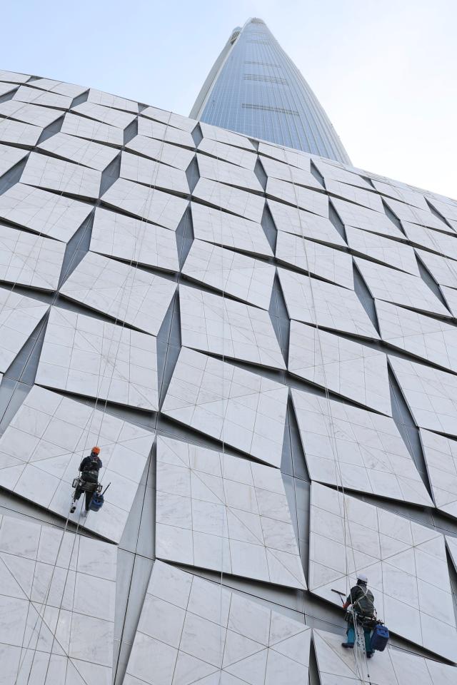 Rope access workers wash the exterior wall of a building near Jamsil Seoul as fine dust levels reach unhealthy levels April 21 2026 AJP Han Jun-gu